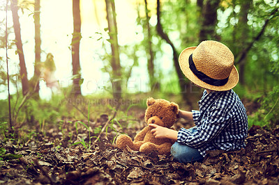 Buy stock photo Shot of a little boy sitting in the forest with his teddy bear