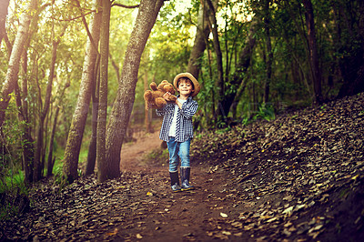 Buy stock photo Shot of a little boy sitting in the forest with his teddy bear