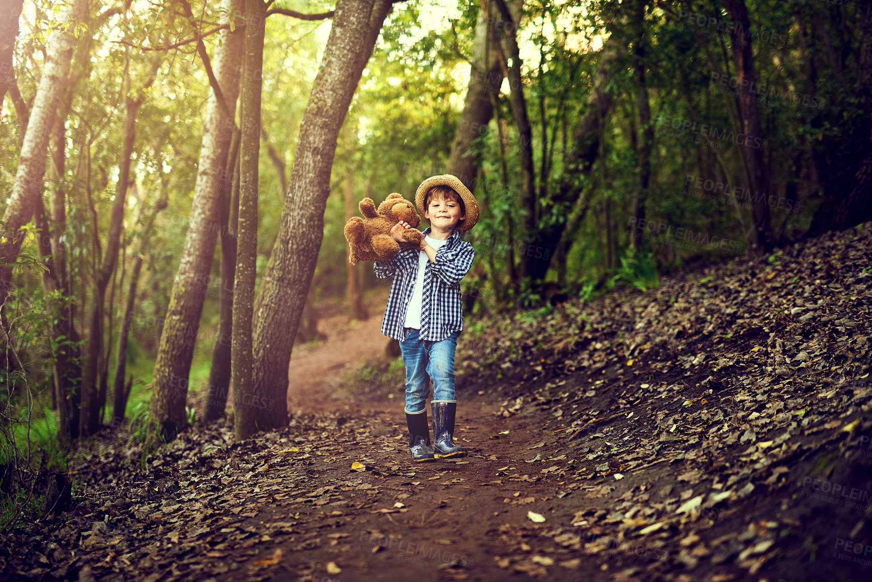 Buy stock photo Shot of a little boy sitting in the forest with his teddy bear