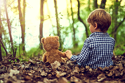 Buy stock photo Young boy, teddy bear and comfort in forest for adventure with embrace and support in nature. Toddler, male kid and stuffed animal in woods with trees for fun, relax and exploration or discovery