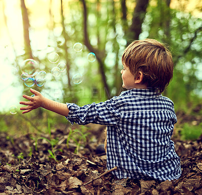 Buy stock photo Boy, forest and playing with bubbles in nature for fun, games and happy on earth day or climate change in future. Back of child or kid relax in woods with childhood, growth and outdoor development