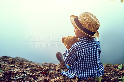 Buy stock photo Relax, teddy bear and boy in nature by lake for fun summer vacation, holiday and weekend alone. Back view, water mockup space or young kid toddler with toy, peace or autumn leaves outdoors in Germany