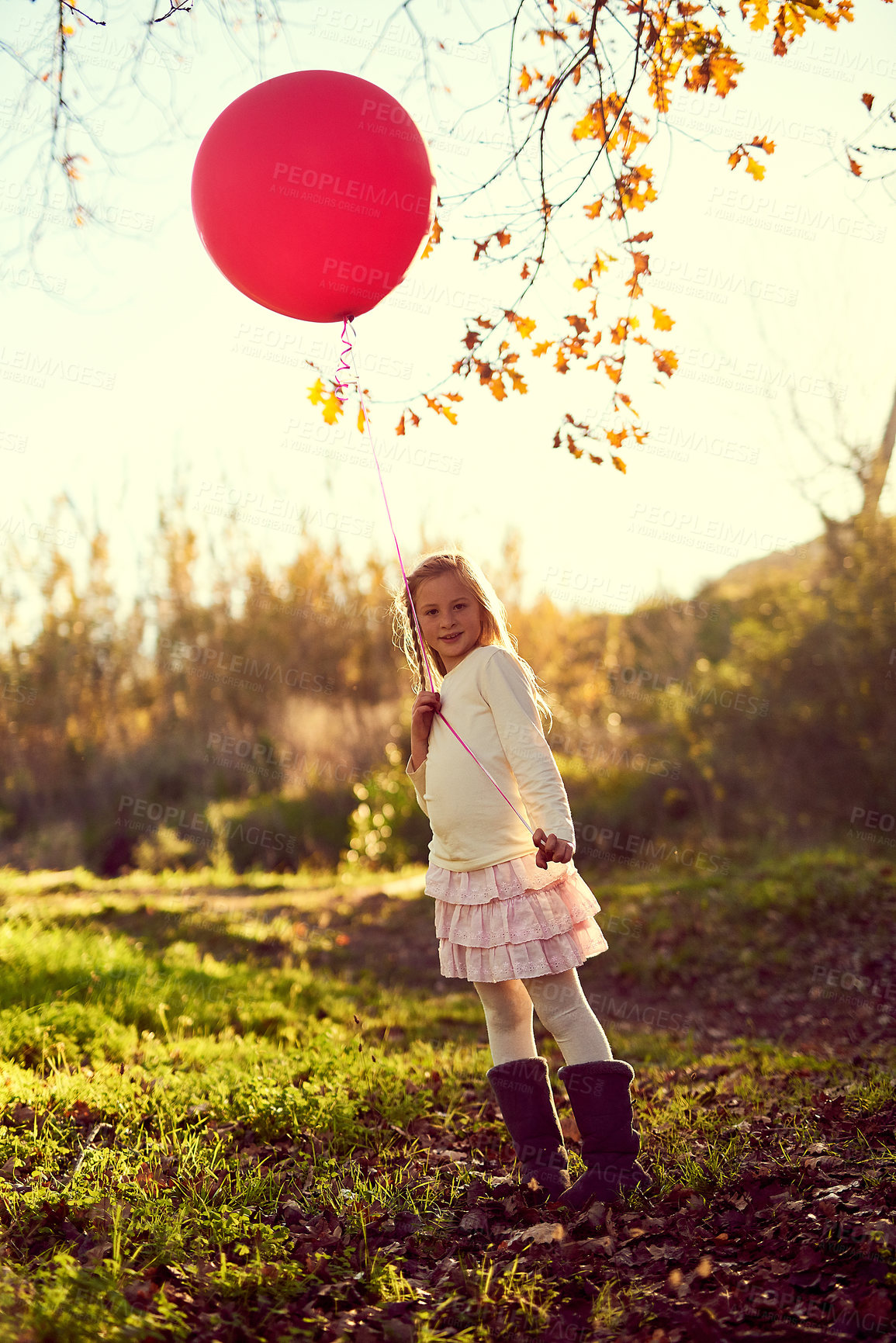 Buy stock photo Portrait, balloon and sunlight for girl in forest, nature and park for birthday party in woods. Childhood development, celebration and smile for young child person, happy and relax or play in grass