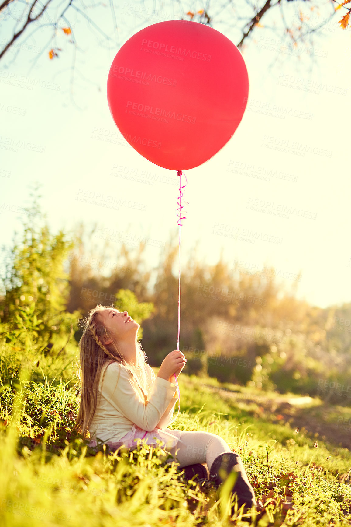 Buy stock photo Shot of a young girl playing with a balloon outside