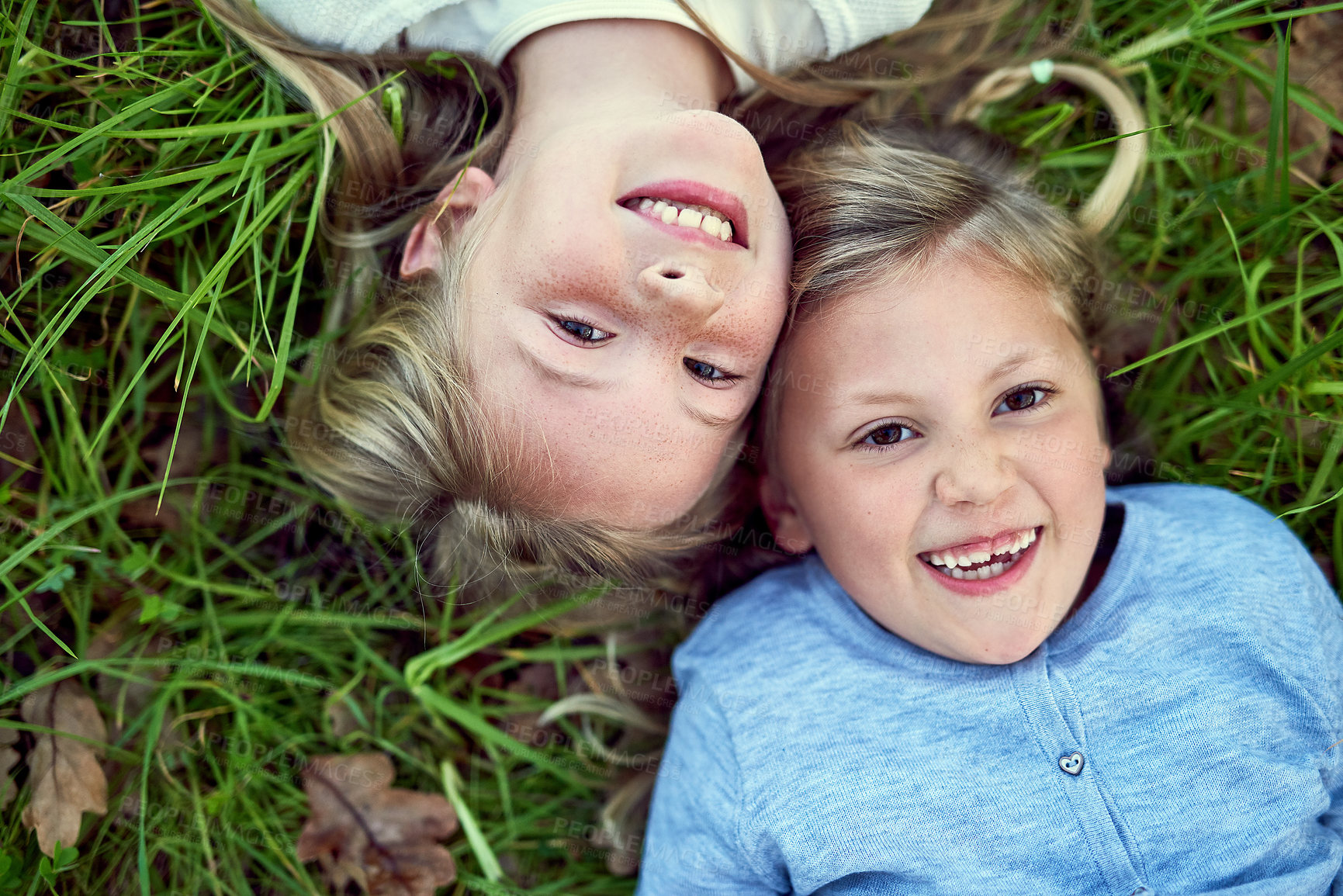 Buy stock photo Top view, portrait and happy kids on grass outdoor for bonding, play and family relax at park. Above, face and laughing children on lawn, girls and funny sisters together at garden on summer holiday
