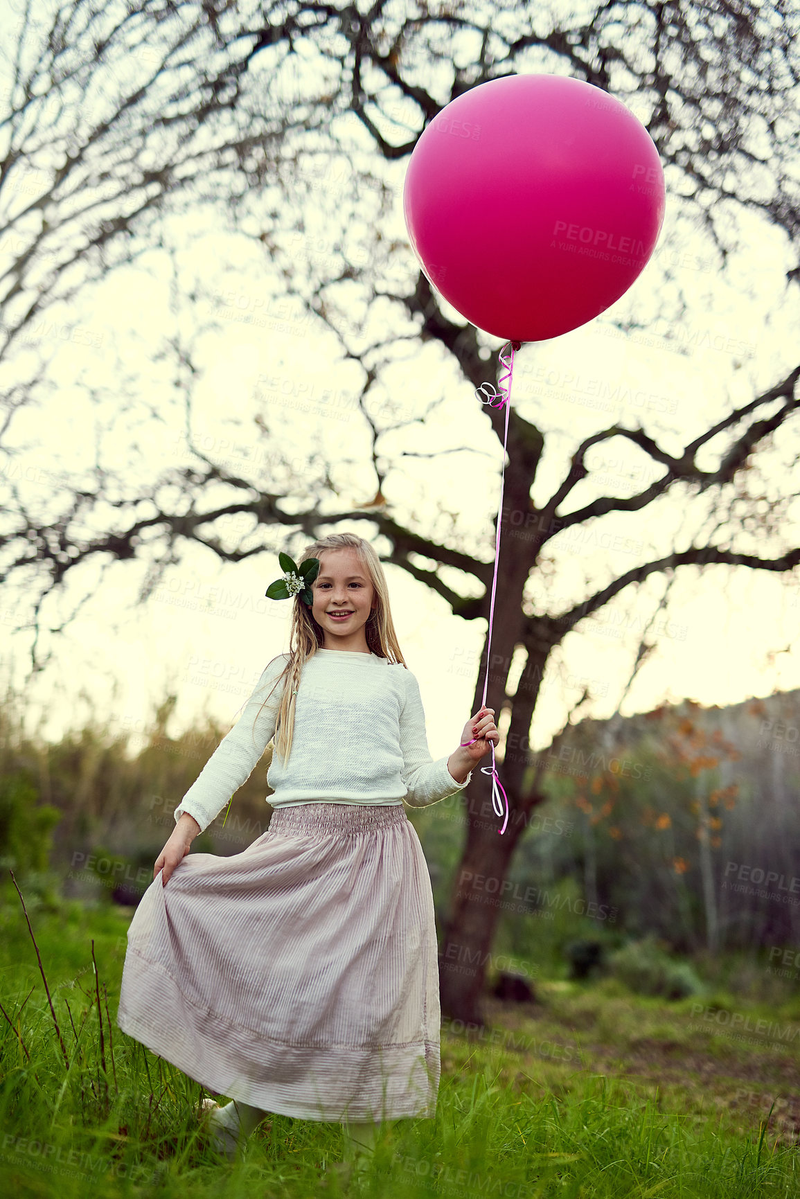 Buy stock photo Portrait, balloon and sunlight for girl in forest, nature and park for birthday party in woods. Childhood development, celebration and smile for young child person, happy and relax or play in grass