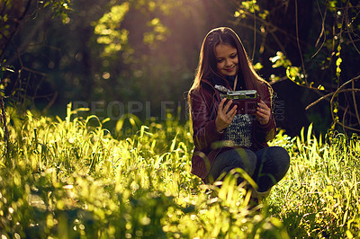 Buy stock photo Shot of a young girl taking a selfie with a vintage camera outdoors