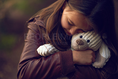 Buy stock photo Cropped shot of a young girl hugging her teddy bear outside