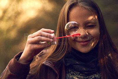 Buy stock photo Portrait of a young girl playing with bubbles outside