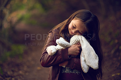 Buy stock photo Hug, hiking or love with girl and teddy bear outdoor in forest for safety, security or comfort. Happy, kids and smile with young child embracing toy rabbit in nature or woods for adventure and trip
