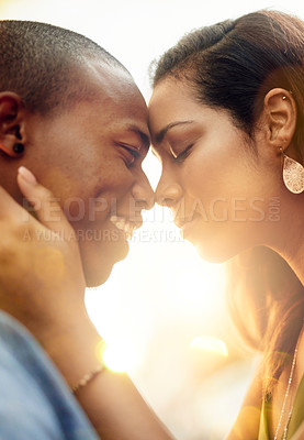 Buy stock photo Shot of an affectionate young couple sharing a tender moment outdoors