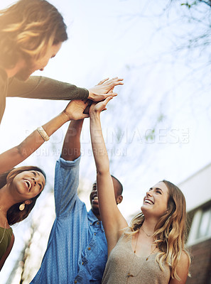 Buy stock photo Shot of a group of young friends giving each other a high five