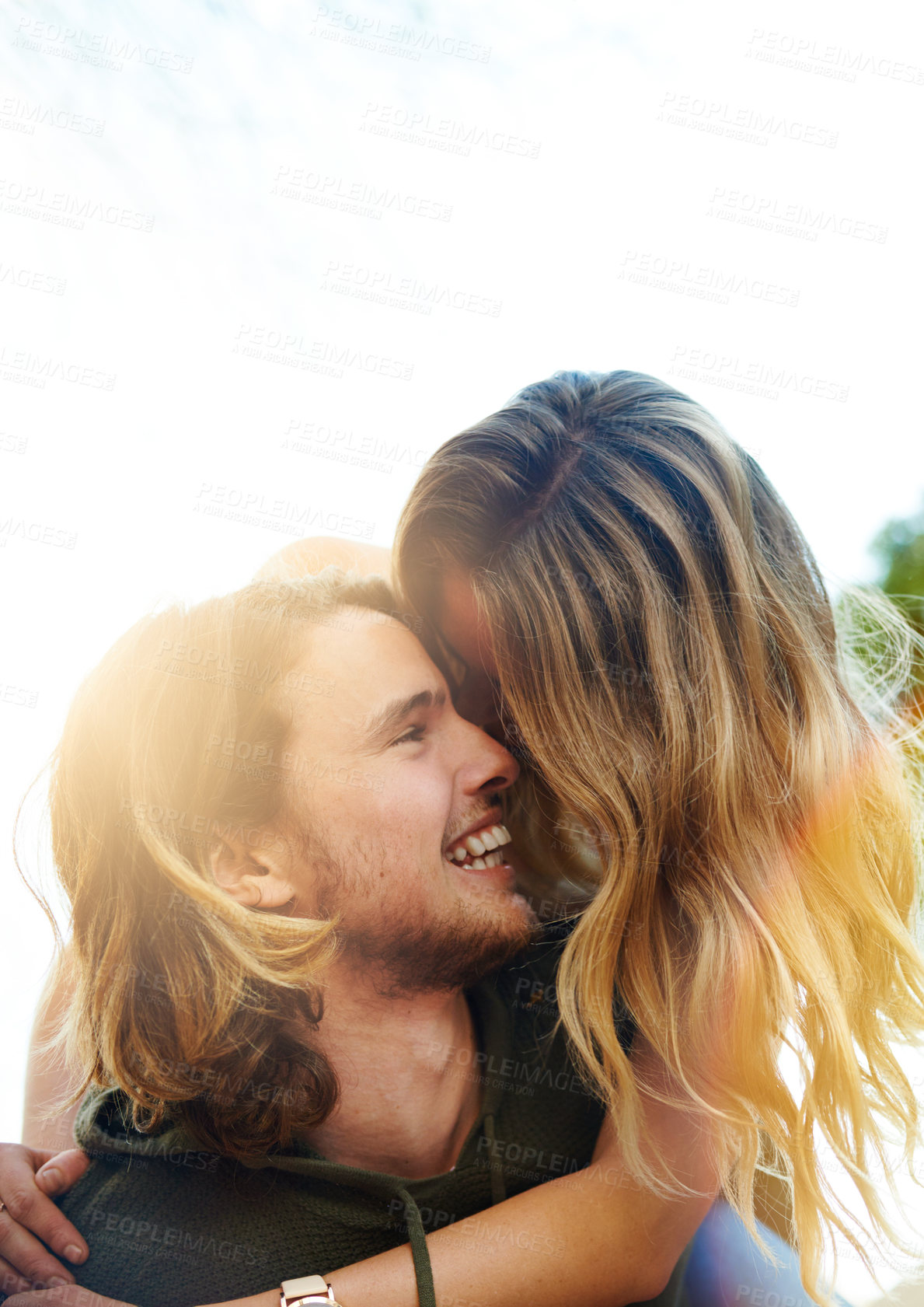 Buy stock photo Shot of a happy young couple enjoying a piggyback ride outdoors