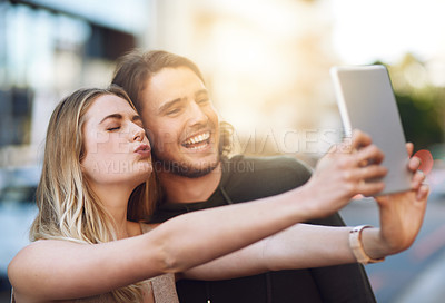 Buy stock photo Portrait of a happy young couple taking a selfie on their digital tablet