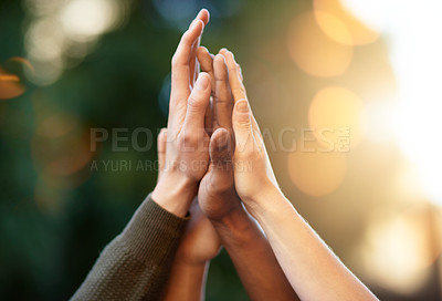Buy stock photo Cropped shot of a group of people giving each other a high five