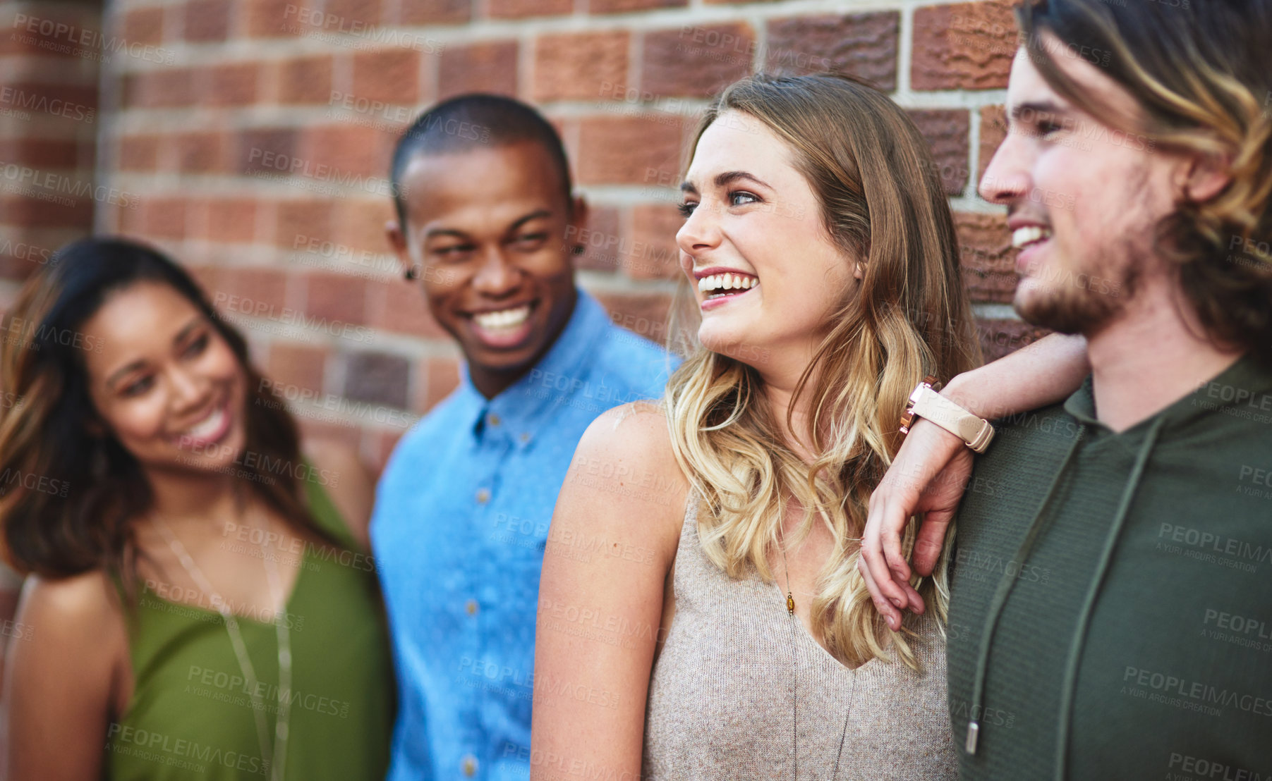 Buy stock photo Happy, bonding and group of friends by brick wall in city for exploring, vacation or adventure. Laughing, hanging out and young people in conversation with diversity together in town on holiday.