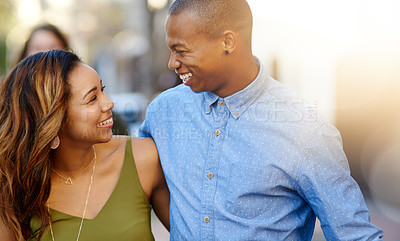 Buy stock photo Shot of a happy young couple taking a walk through the city