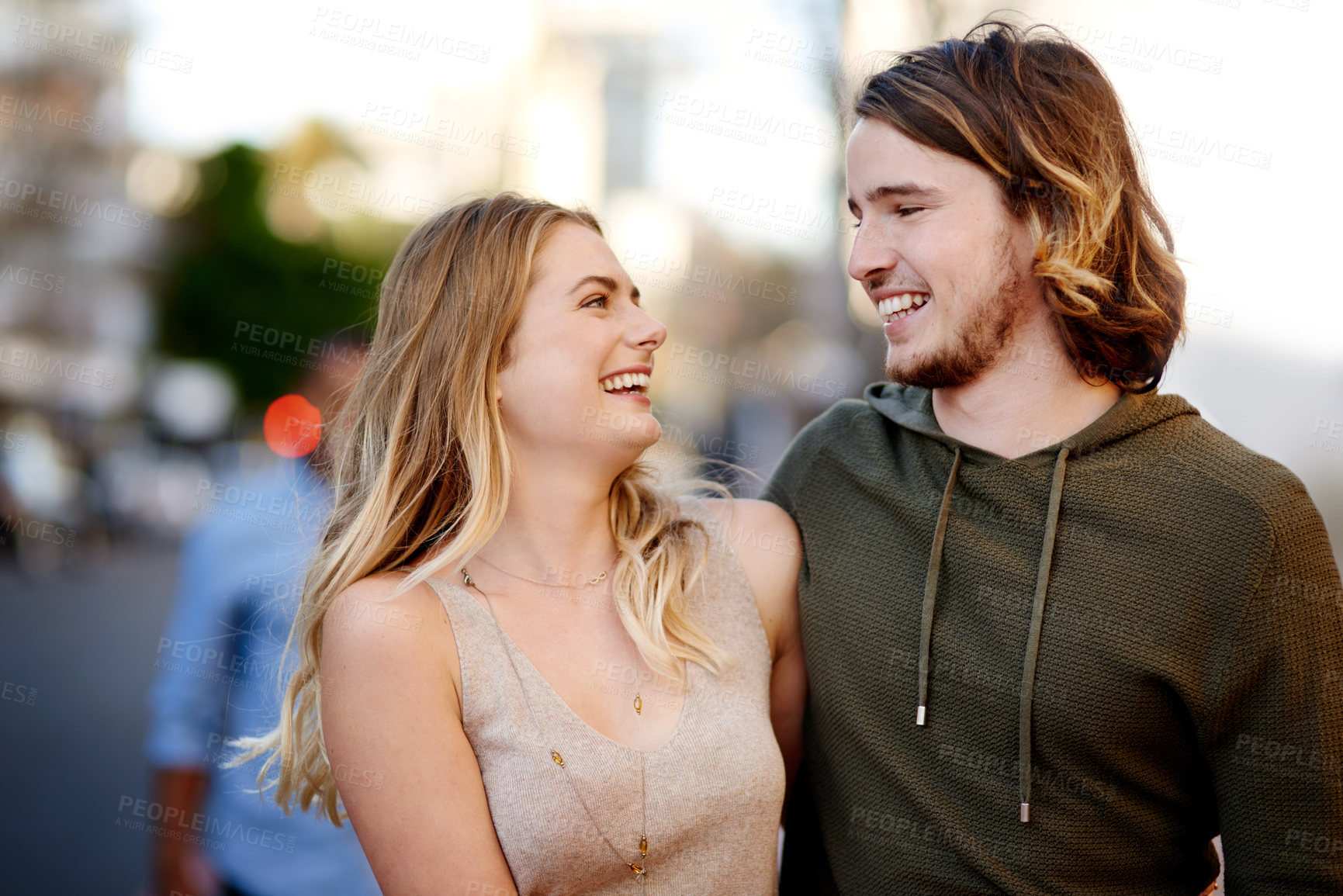 Buy stock photo Shot of a happy young couple taking a walk through the city