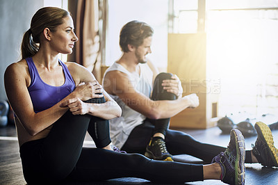 Buy stock photo Shot of two young people warming up before their workout