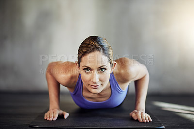 Buy stock photo Shot of an attractive young woman doing pushups as part of her workout