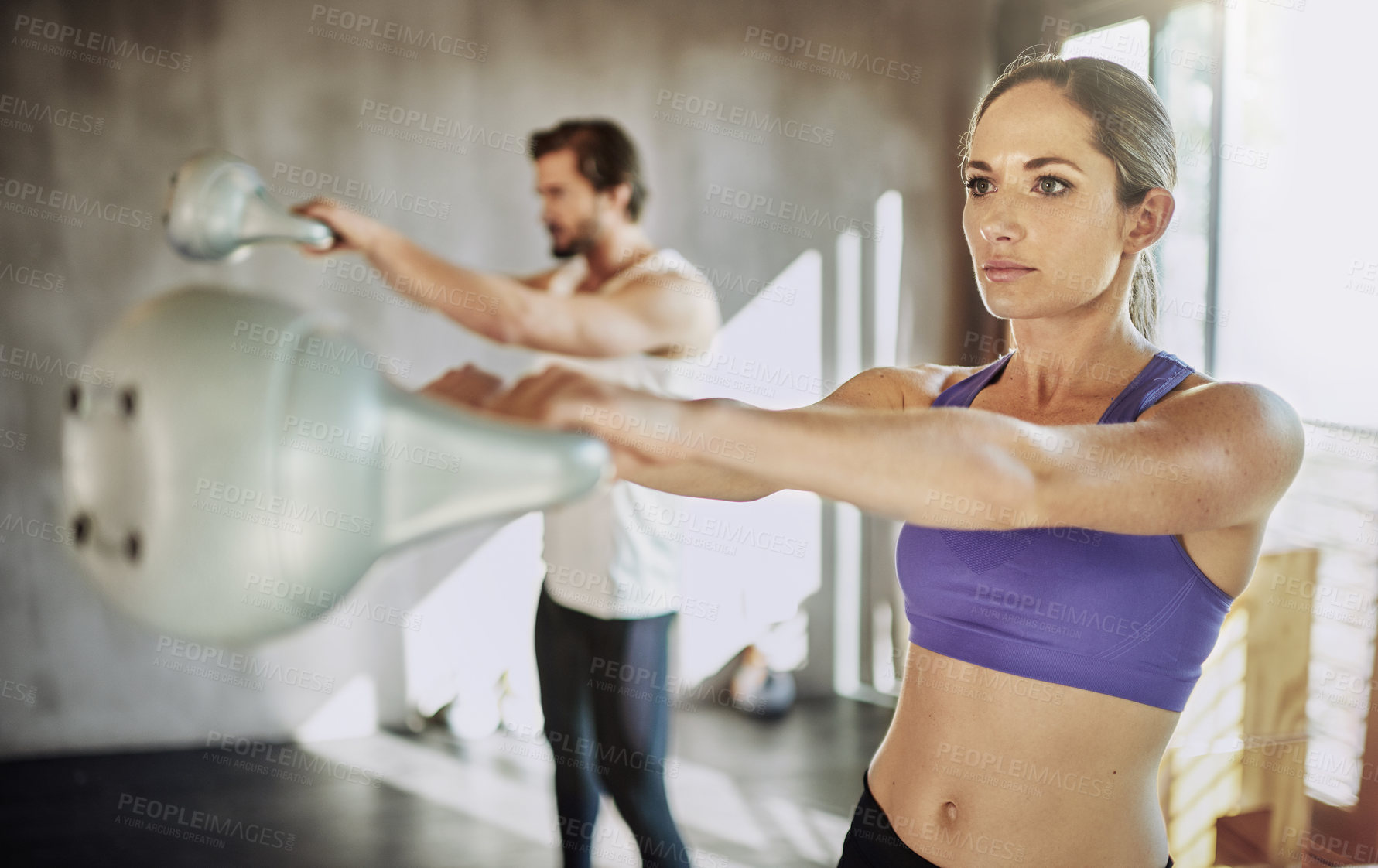 Buy stock photo Exercise, man and woman in gym with kettlebell, training and power at workout challenge together. Couple, sports partner or personal trainer with weights, muscle development and healthy body fitness.