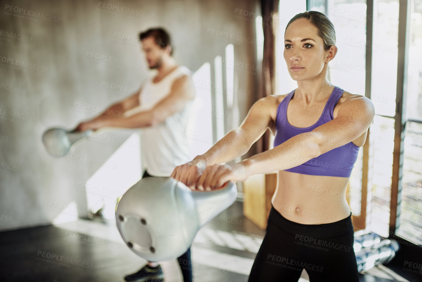 Buy stock photo Fitness, man and woman in gym with kettlebell, training and power at workout challenge together. Couple, sports partner or personal trainer with weights, muscle development and healthy body exercise.