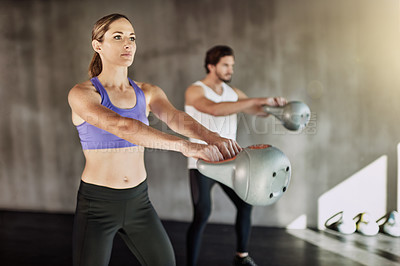 Buy stock photo Training, man and woman in gym with kettlebell, fitness and power at workout challenge together. Couple, sports club and personal trainer with weights, muscle development and healthy body exercise