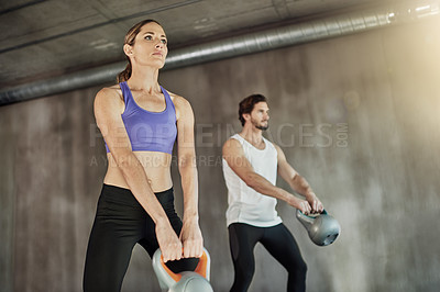 Buy stock photo Training, exercise and couple in gym with kettlebell, power and workout challenge together at sports club. Man, woman and personal trainer with weights, muscle development and healthy body fitness.