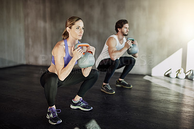 Buy stock photo Workout, squat and couple in gym with kettlebell, power training and fitness challenge together at sports club. Man, woman or personal trainer with muscle development, healthy body and exercise.
