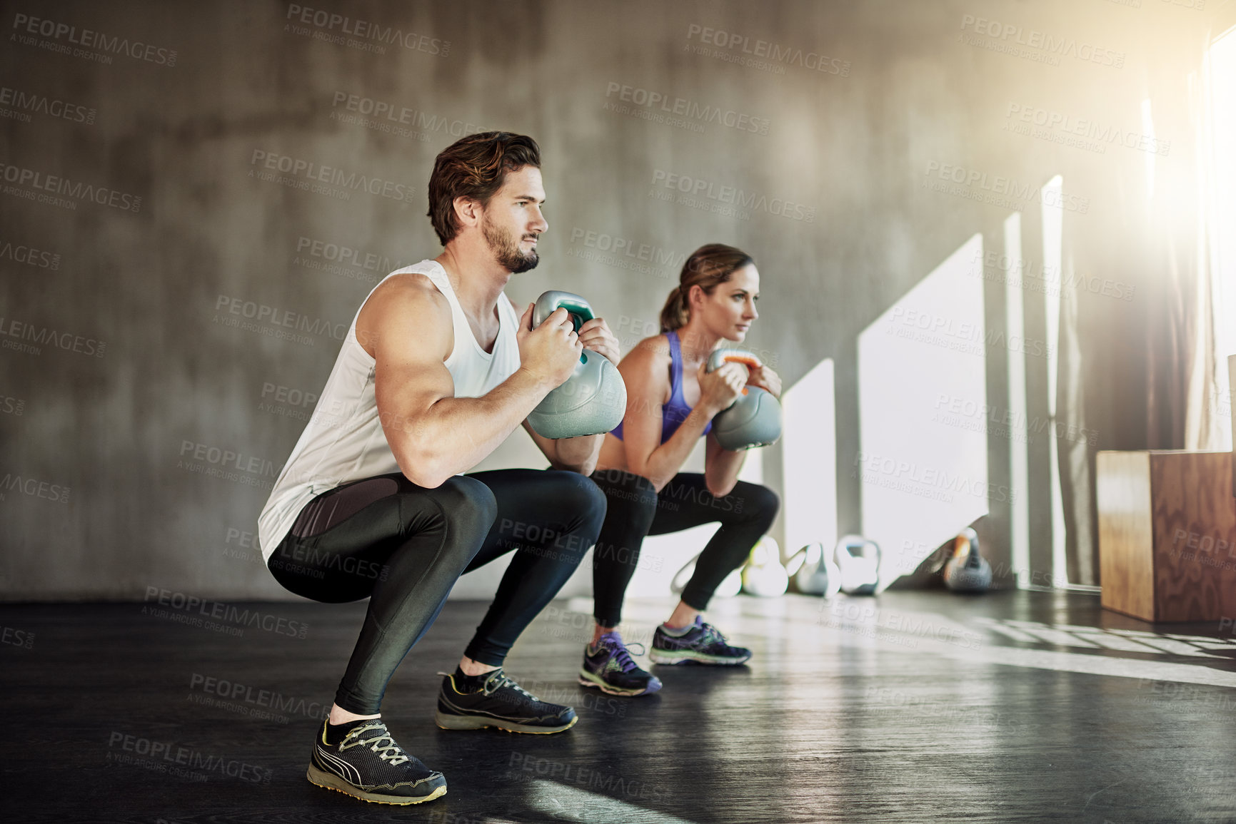 Buy stock photo Training, squat and couple in gym with kettlebell, power fitness and workout challenge together at sports club. Man, woman or personal trainer with muscle development, healthy body and exercise.