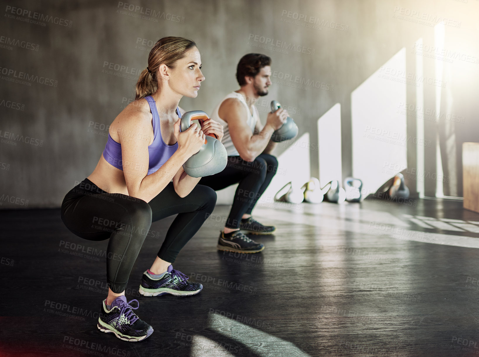 Buy stock photo Muscle, squat and couple in gym with kettlebell, power training and workout challenge together at sports club. Man, woman or personal trainer with fitness development, healthy body and exercise.