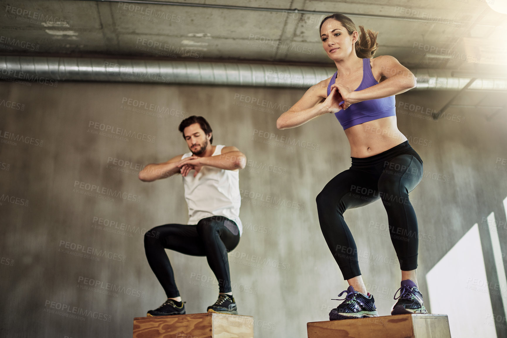 Buy stock photo Jumping, man and woman in gym with box, fitness and power training at workout challenge together. Couple, sports club and personal trainer with balance, muscle development and healthy body exercise