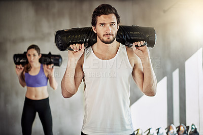Buy stock photo People, fitness and sandbag exercise for gym training or weightlifting for muscle growth, workout or friends. Man, woman and personal trainer with equipment as athlete teamwork, sports or activity