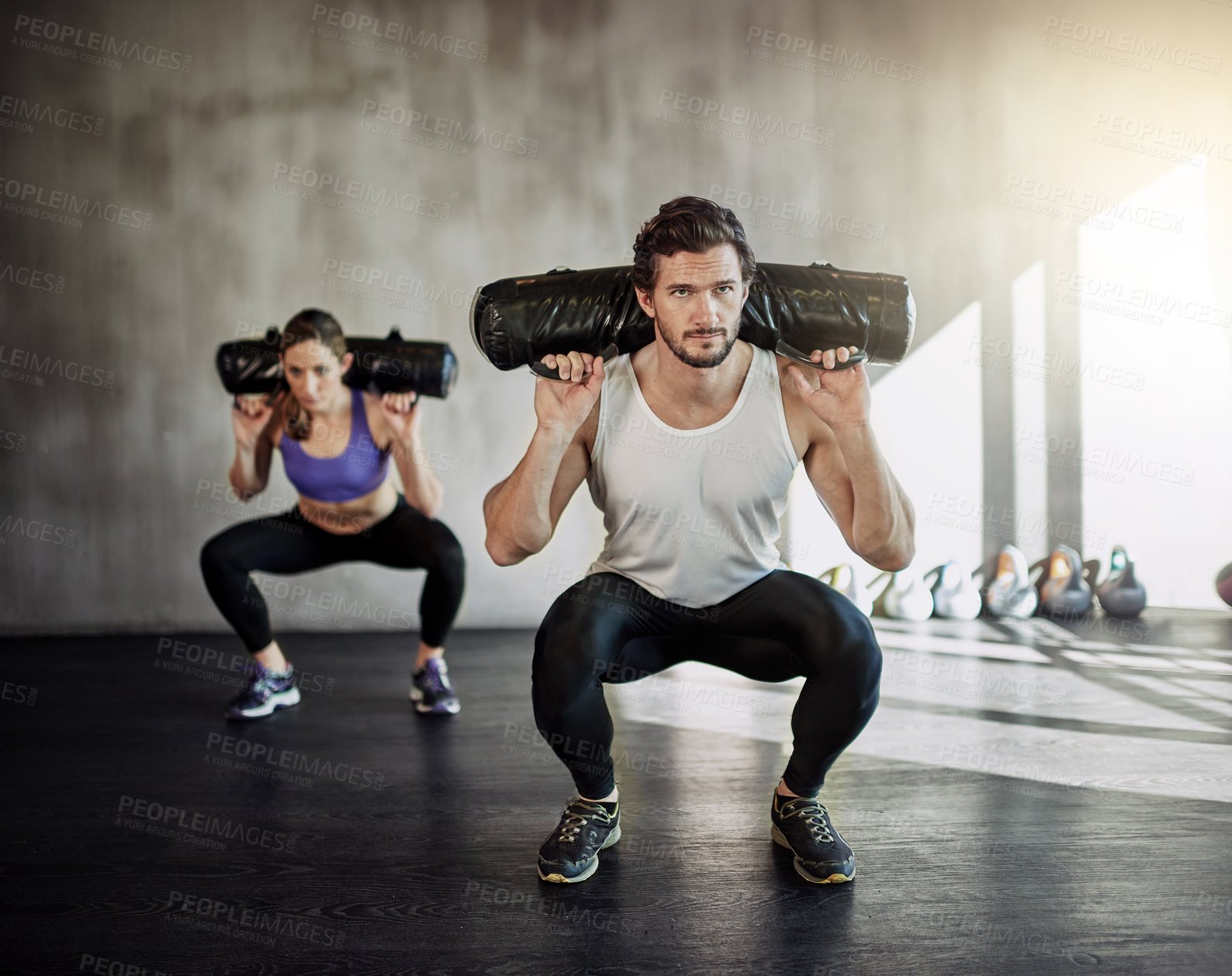 Buy stock photo Man, woman and squat with sandbag for gym exercise or leg strength for muscle building, discipline or athlete. Personal trainer, client and weightlifting class for sports goals, workout or fitness