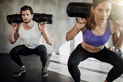 Buy stock photo Man, woman and squat with sandbag weights for exercise performance, training or muscle. Personal trainer, friends and discipline or teamwork goals with workout wellness or glutes, core or fitness