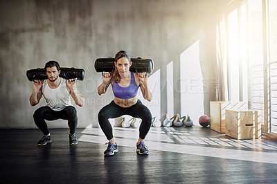 Buy stock photo Fitness, health and strong with people lifting weighted bags in the gym during a workout for physical power. Exercise, weightlifting or sports with a man and woman bodybuilder training for wellness
