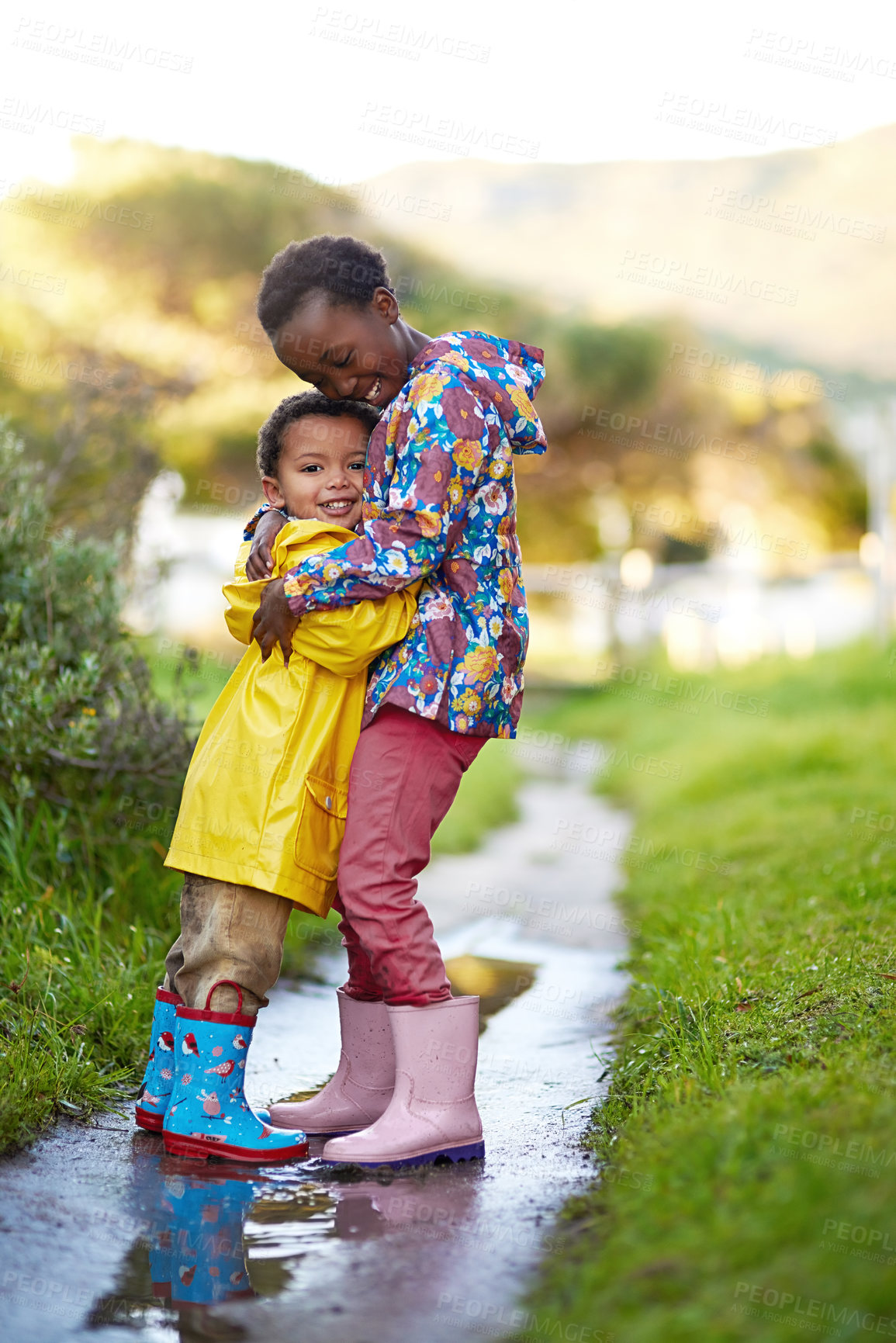 Buy stock photo Shot of a brother and sister hugging together outside