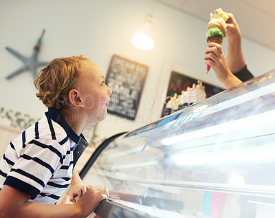 Buy stock photo Cropped shot of a young boy eagerly waiting for an ice cream cone