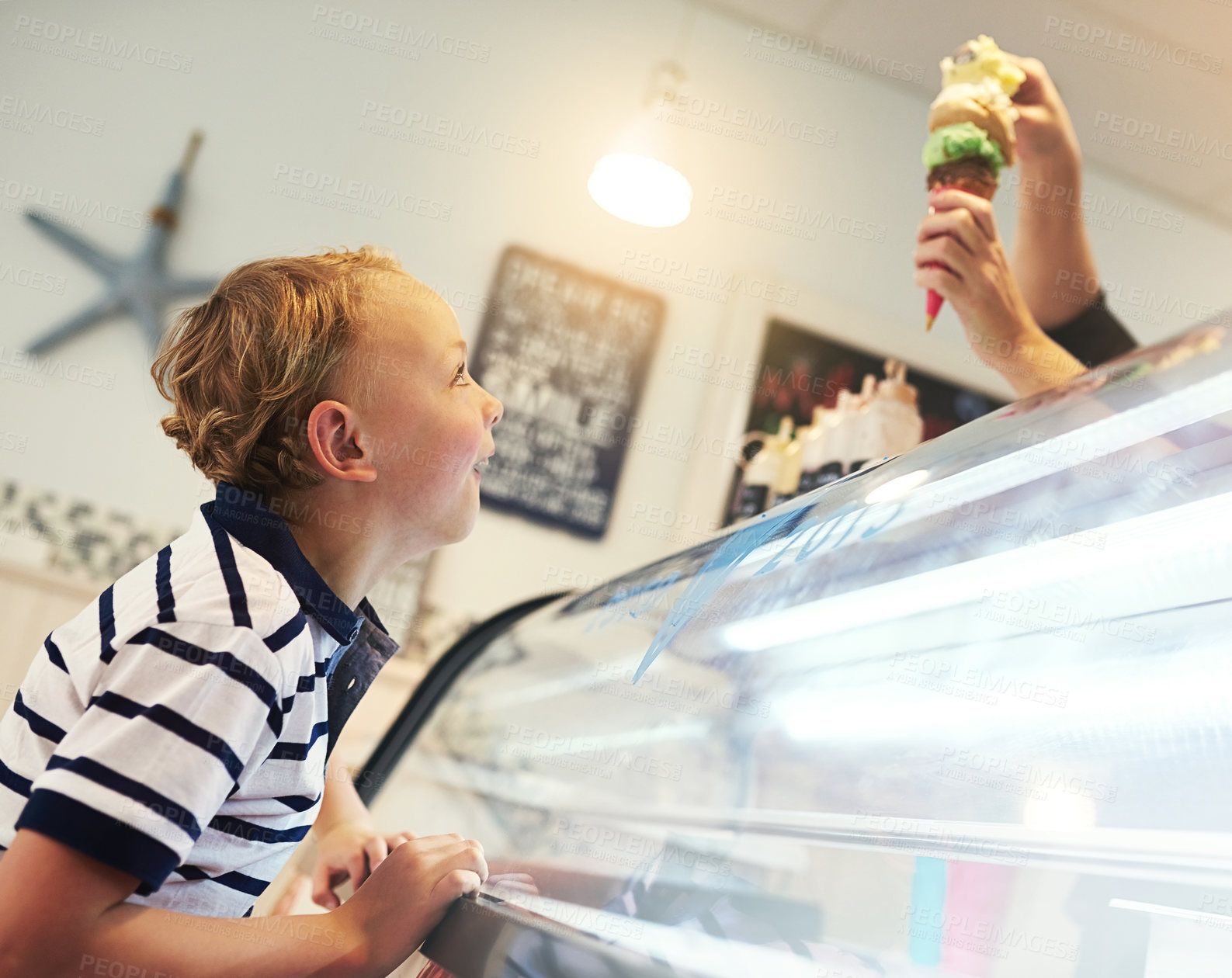 Buy stock photo Cropped shot of a young boy eagerly waiting for an ice cream cone