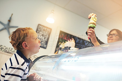 Buy stock photo Ice cream, happy and child in store for dessert with worker serving dessert for sweet treat. Excited, craving and server with scoop of frozen gelato in cone for boy kid customer in dairy shop.