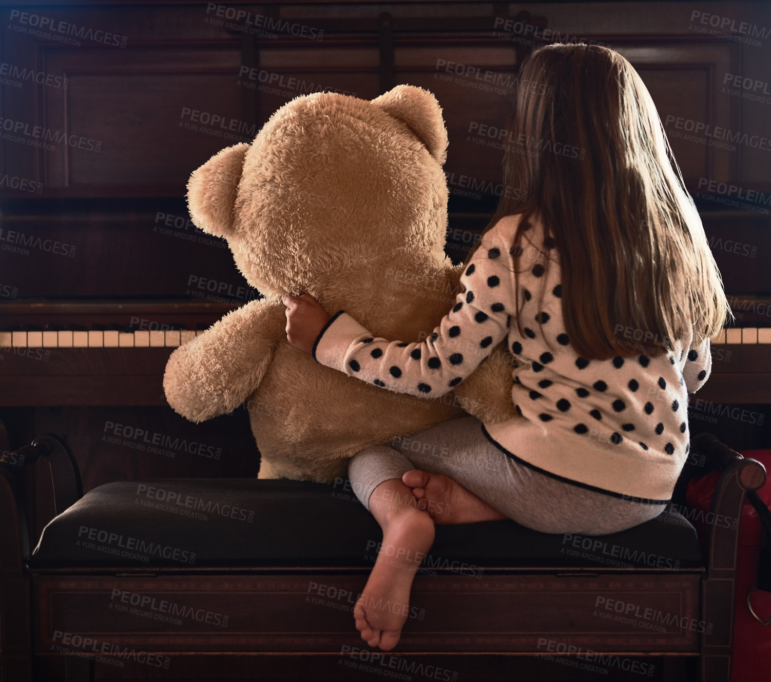 Buy stock photo Rear view shot of a little girl sitting in front of a piano with her teddy bear