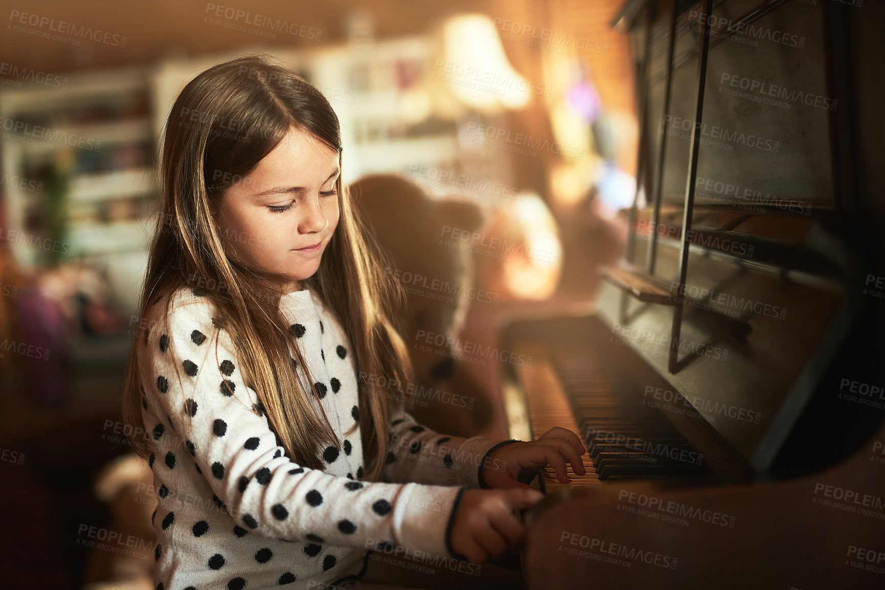 Buy stock photo Cropped shot of a little girl playing the piano at home