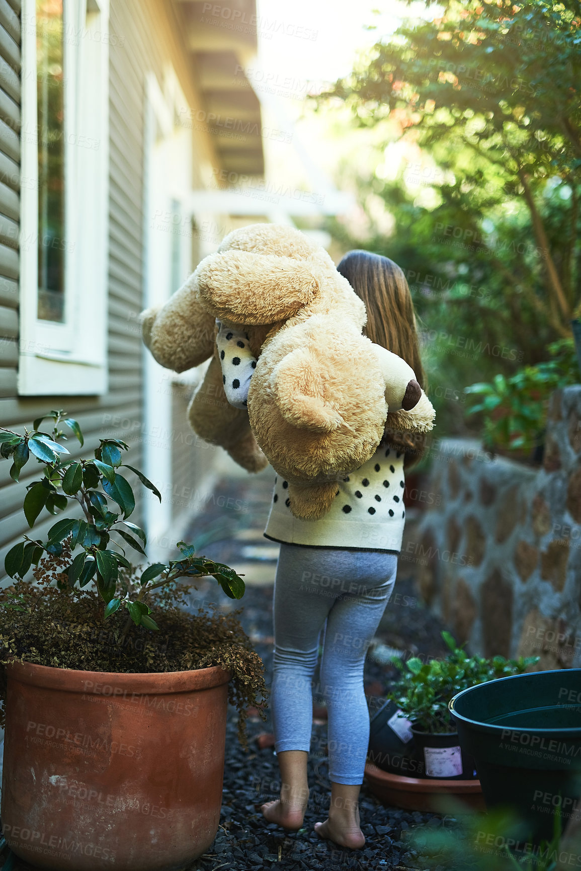 Buy stock photo Rear view shot of a little girl carrying her teddy bear outside