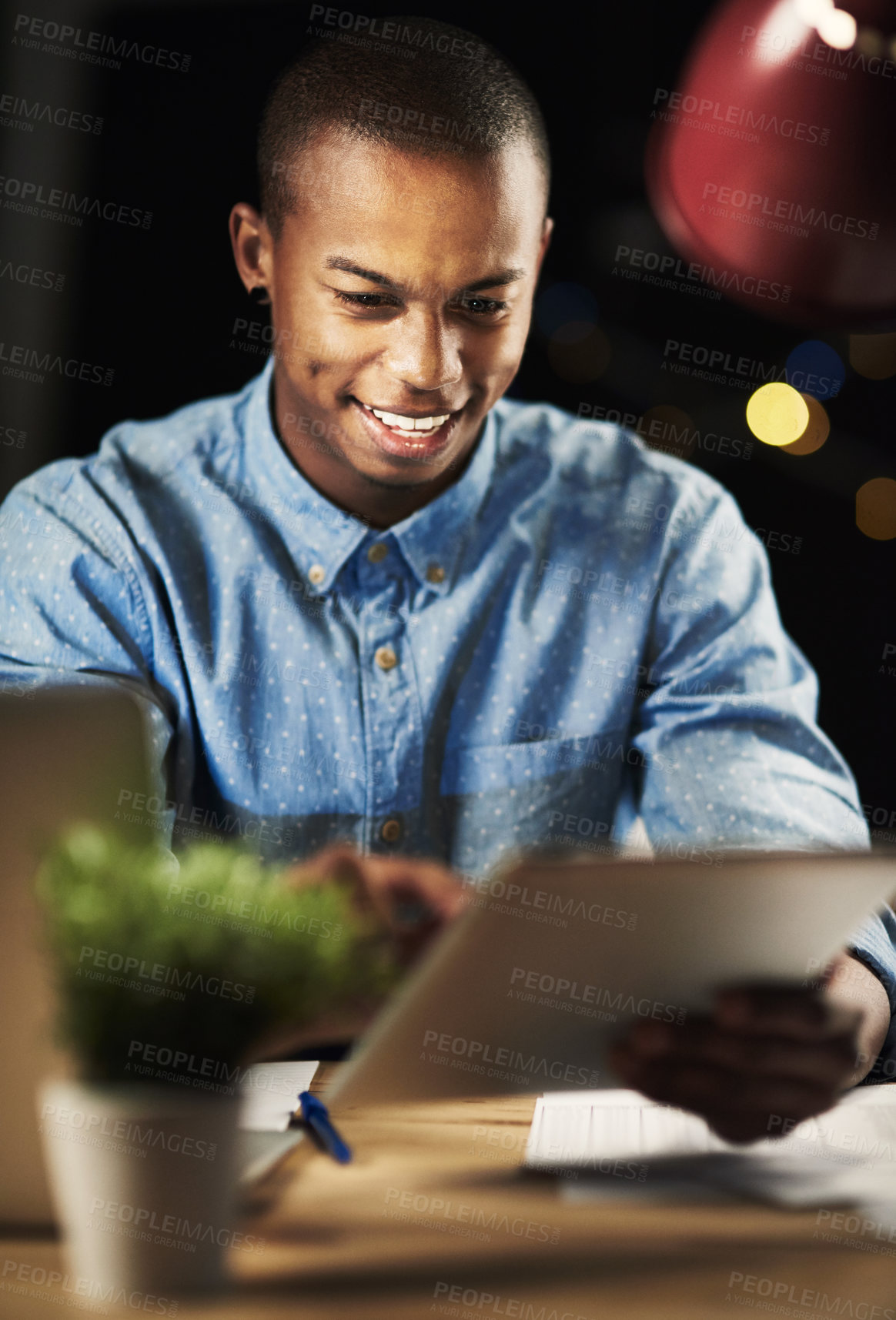 Buy stock photo Shot of a handsome young man working late in the office