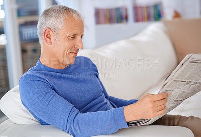 Buy stock photo Senior, man and reading a newspaper on couch for article, information or morning routine in living room of home. Elderly, person and media story for global news, knowledge or relax with smile on sofa