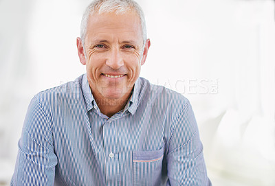 Buy stock photo Portrait of a smiling mature man sitting on a sofa in his living room