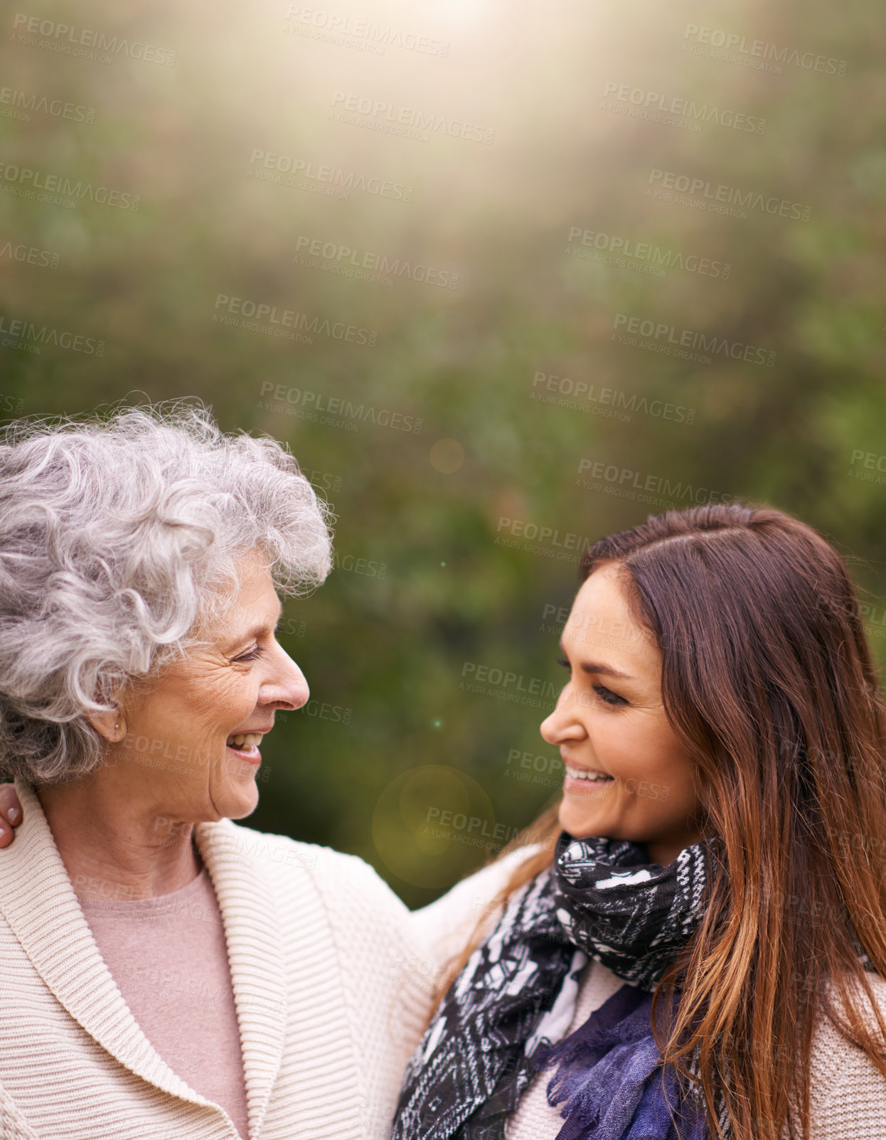 Buy stock photo Shot of an attractive woman and her senior mother talking outside
