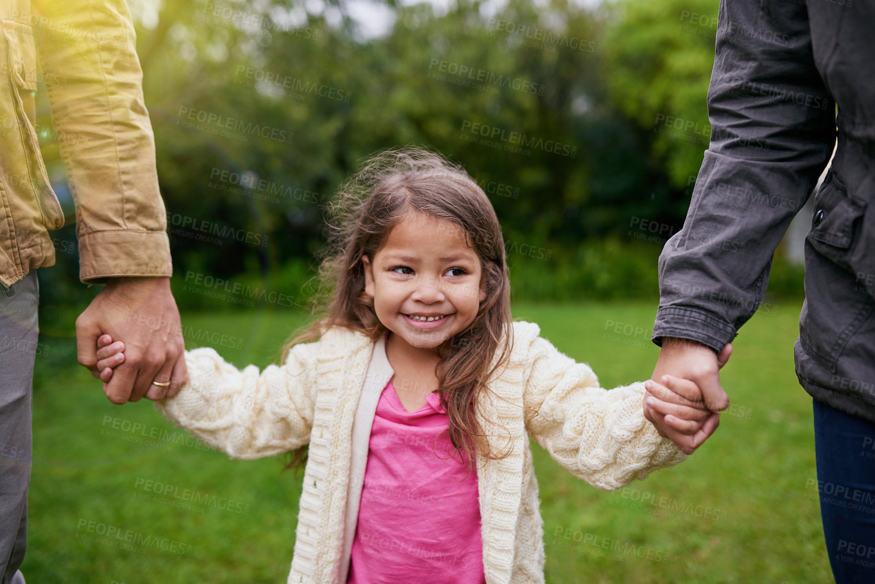 Buy stock photo Smile, parents and child holding hands in park with care, support and trust on outdoor adventure. Love, fun and face of girl with family in garden for happy holiday, nature or walking in backyard