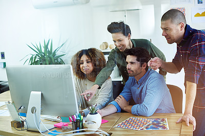 Buy stock photo Shot of a group of coworkers gathering behind a computer to discuss ideas