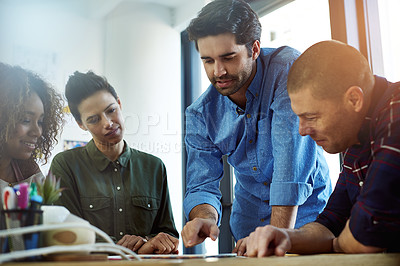 Buy stock photo Cropped shot of a group of coworkers discussing something on a tablet